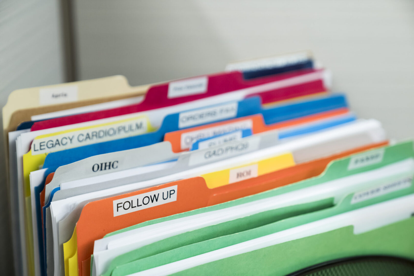 A close up of several folders with different colored papers.