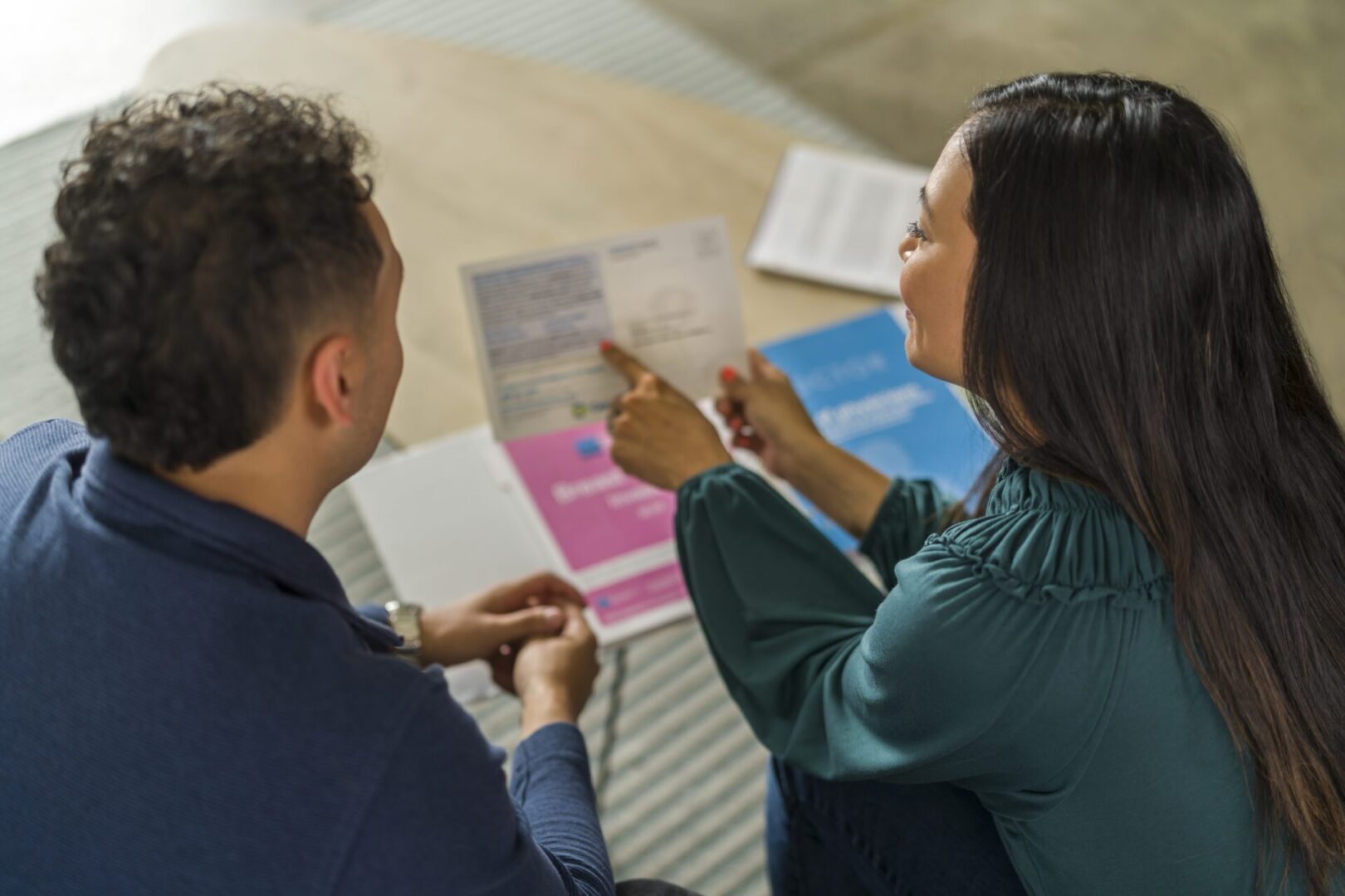 A woman and man are looking at papers.